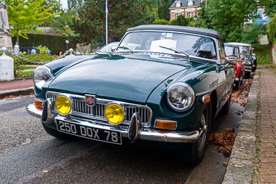 Cabriolet britannique vert foncé aux phares jaunes à Épône