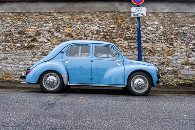 Volkswagen Coccinelle bleu clair garée devant un mur de pierre à Épône