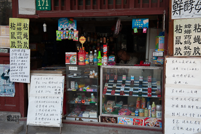 Boutique de quartier couverte d'affiches et de panneaux à Shanghai