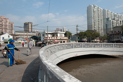Canal et passerelle entre quartiers anciens et immeubles modernes à Shanghai