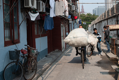 Transport d'une lourde charge dans une ruelle de Shanghai