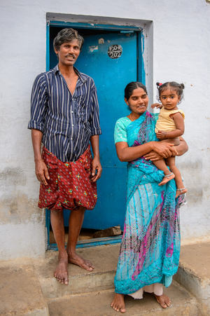 Une famille devant la porte de sa maison