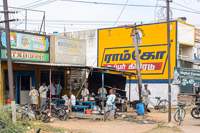 Une cuisine de rue devant une publicité pour le ciment Ramco Supergrade, près du restaurant Mughal Express.