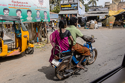 Une passagère en sari voyage assise en amazone à l'arrière d'une moto.