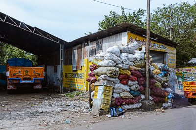 Des sacs de matières récupérées forment une muraille devant un dépôt de plastiques.