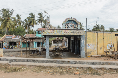 Un petit temple hindou se dresse parmi les maisons basses et les cocotiers.