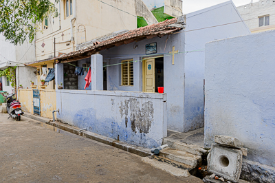 Un modeste bâtiment bleu marqué d'une croix s'insère parmi les maisons du quartier.