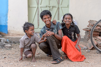 Les trois enfants resserrent leur pose et offrent au photographe de larges sourires.