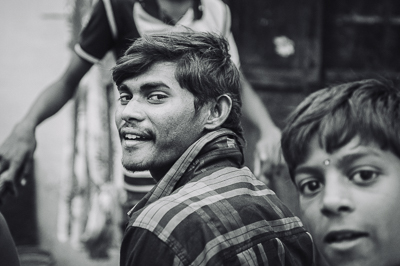 Portrait en noir et blanc d'un adolescent qui se retourne, tandis qu'un enfant surgit au premier plan.