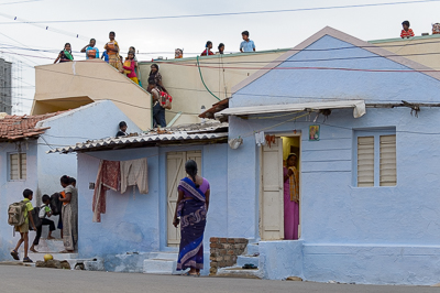 Femmes et enfants observent la séance depuis la rue, un escalier et les terrasses des maisons.