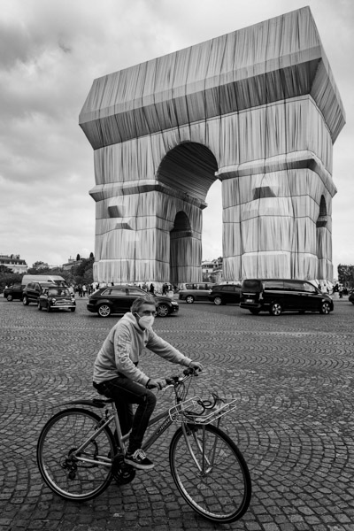 Le cycliste, l’Arc et les pavés composent trois échelles dans une même image.