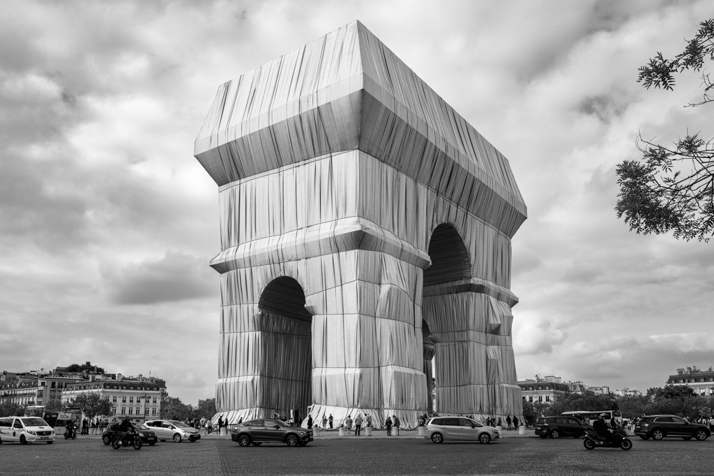 L’Arc de Triomphe empaqueté, massif et provisoire, au milieu de la circulation parisienne.