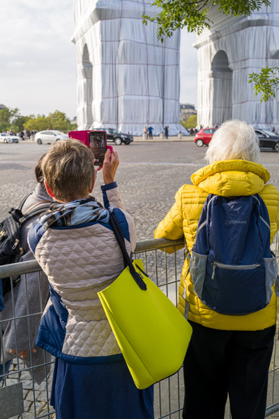 À hauteur de barrière, deux visiteuses cherchent leur point de vue sur l’installation.