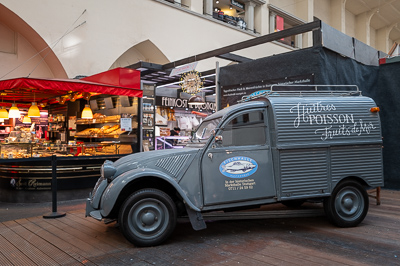 Markthalle, Stuttgart.
Ici, pas de Porsche ni de Mercedes : une 2CV fourgonnette grise sert d’enseigne à un marchand de poissons et fruits de mer. Clin d’œil français au milieu du grand marché couvert.