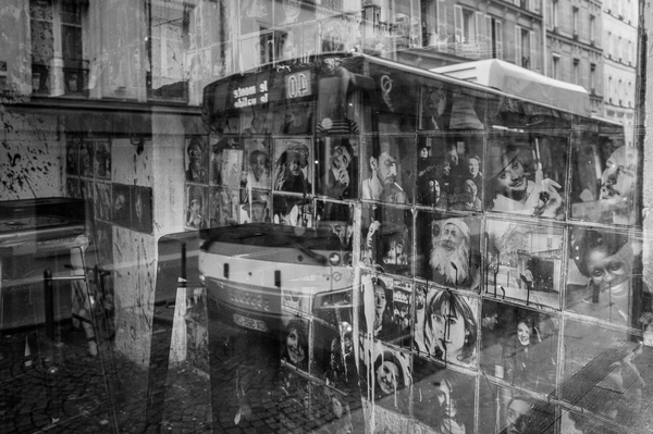Reflet d’un bus parisien passant devant une vitrine de portraits en noir et blanc, comme s’il venait les ramasser